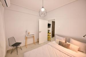 拉里萨Modern, comfortable apartment, in the heart of the city_2的一间卧室配有一张床、一把椅子和一张书桌