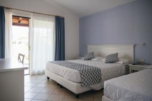 布多尼SECRET VILLAGE Budoni的酒店客房设有两张床和窗户。