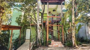 乌巴图巴Pousada Ubatuba do Alto的一座带木制楼梯的绿色房子