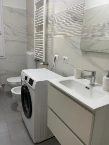 费拉拉Daisy House的白色的浴室设有洗衣机和水槽。