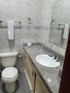 瓜亚基尔OCEANIk SUITES & HOTEL的浴室配有白色卫生间和盥洗盆。