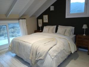吉亚迪诺镇Chacra La Invernada Pequeño Hotel de Campo的卧室配有一张大白色床和窗户