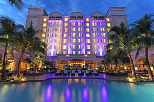 马那瓜马那瓜梅特罗森特洲际酒店的夜间有游泳池和棕榈树的酒店