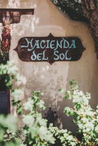陶斯Hacienda Del Sol的植物建筑的一侧的标志