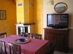加尔多内-里维耶拉Villa Panorama Residence的一间带桌子和平面电视的用餐室