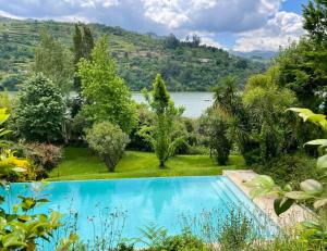 Santa Cruz do Douro5 bedrooms house with lake view shared pool and enclosed garden at Santa Cruz do Douro 1 km away from the beacha的花园内的游泳池,花园的后面是湖泊