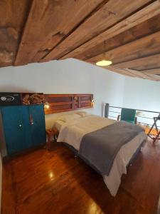 危地马拉安地瓜Cozy Bohemian Loft Apartment close Central Plaza的一间带一张大床的卧室,位于一个拥有木制天花板的房间