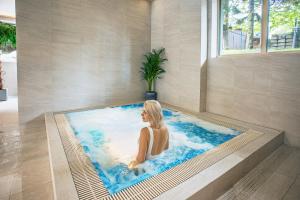 扎科帕内Villa Cannes Resort Zakopane - grota solna, sauna fińska的坐在游泳池浴缸中的女人