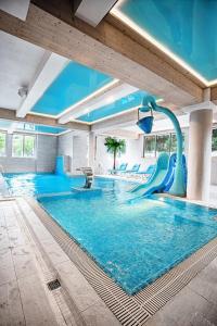 扎科帕内Villa Cannes Resort Zakopane - grota solna, sauna fińska的一座大楼内带水滑梯的游泳池