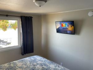 奥沙克湖Lakeshore Fishing cabin 1 , dock/boat slip, fire pit.的卧室设有壁挂式电视和床。