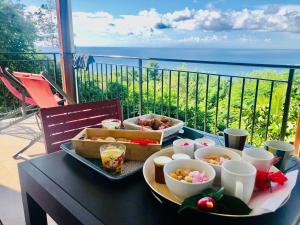 圣吕斯Magnifique Villa Bauhinia, Piscine vue mer的阳台上的桌子和食物托盘