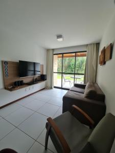 拉巴拉德纳圣米格尔ILOA Condomínio Resort Barra de São Miguel的一间卧室配有一张床、一台电视和一把椅子
