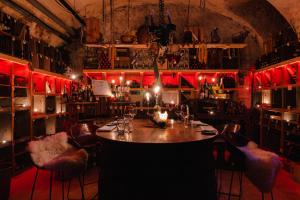 莱茵河畔威尔Ott's Hotel Weinwirtschaft & Biergarten Weil am Rhein/Basel的红灯房间里带桌子的酒吧