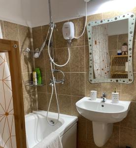 布加勒斯特Cozy and Clean Apartment, near National Arena的带淋浴、盥洗盆和镜子的浴室