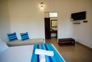雅拉Ranakeliya Lodge - Yala的一间酒店客房,配有一张床和一台电视