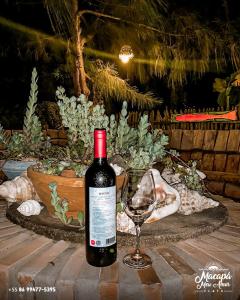 路易斯科雷亚FLATS MACAPÁ MEU AMOR 7的一瓶葡萄酒和一杯酒在桌子上