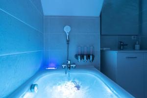 芒德Le Bohème - Spa/Netflix/Wifi Fibre - Séjour Lozère的带浴缸的浴室和蓝色灯光