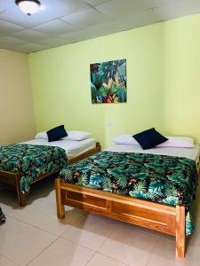 拉斯塔布拉斯Hostal VILLAS DON PABLO LAS TABLAS的两张睡床彼此相邻,位于一个房间里