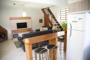 新弗里堡Casa em Friburgo com piscina lareira suíte & quarto的厨房以及带桌椅的起居室。