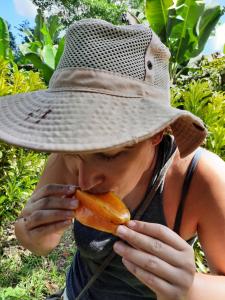Palmar SurLa Muñequita Lodge 2 - culture & nature experience的戴帽子吃胡萝卜的女人