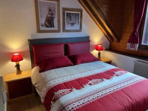 塔尔维西奥Mandi Mandi a Tarvisio的一间卧室配有一张红色大床和两盏灯