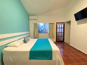 博卡奇卡Calypso Beach Hotel by The Urbn House Santo Domingo Airport的一间卧室配有一张蓝色墙壁的床