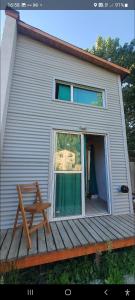 埃博森Sur tiny house的一座带窗户的房子,甲板上设有长凳