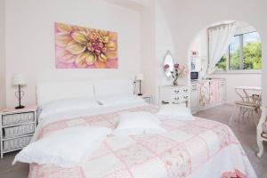 斯普利特Beach apartment Demi的白色卧室配有一张床,墙上挂着一幅画