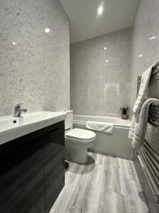 HordenBelsay 4 bedroom bungalow with loft conversion的浴室配有盥洗盆、卫生间和浴缸。