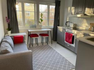 斯德哥尔摩The Studio的厨房配有沙发和带红色椅子的桌子