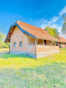 Bosansko Petrovo SeloVikend na Ozrenu的一块砖砌的建筑,在田野上有一个红色的屋顶