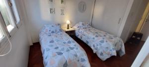 门多萨Apartamento centrico amueblado的小型客房配有两张单人床和一张桌子。