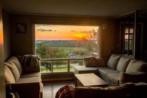 RoseneathCozy Sunset Cottage Overlooking Rice Lake的带沙发和大窗户的客厅