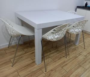 库特诺Apartament Różana Piątka的厨房里配有一张白色的桌子和两把白色的椅子
