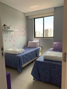 累西腓Apartamento com estilo e conforto的客房设有两张床和窗户。