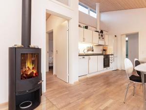 博恩瑟6 person holiday home in Bogense的厨房以及带壁炉的客厅。