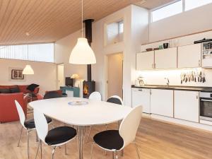 博恩瑟6 person holiday home in Bogense的用餐室以及带白色桌椅的厨房