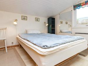 BrunshuseHoliday home Haarby IV的窗户客房内的一张大白色床