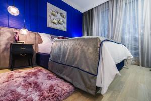 扎达尔DiVine Luxury Apartment Blue的一间拥有蓝色墙壁的卧室和一张铺有地毯的床