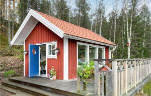 BottnarydAmazing Home In Bottnaryd With Wifi的红色和白色的房子,设有木甲板
