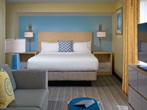 沃里克普罗维斯登斯 - 机场圣淘沙集团酒店的一间卧室配有一张床、一张沙发和一把椅子