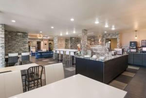 克拉尔维尔SureStay Plus Hotel by Best Western Coralville Iowa City的餐厅设有酒吧,配有桌椅