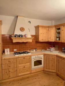 利莫内皮埃蒙特Incantevole 90MQ sulle piste di Limonetto的厨房配有木制橱柜和炉灶烤箱。