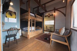 高松Traditional Apartment Takamatsu Guesthouse的客房设有双层床、沙发和椅子。