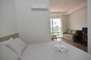 邦比尼亚斯Vila do Centro Apart Hotel的酒店客房,配有带毛巾的床