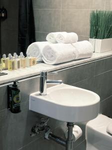 悉尼悉尼精品酒店的一间带水槽和架子毛巾的浴室