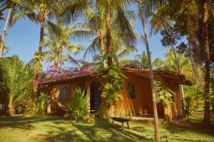 圣米格尔-杜斯米拉格里斯Pousada Peixe do Mato的棕榈树中间的小房子