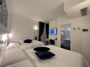 奇维塔韦基亚Hotel Smart Cruise的酒店客房设有两张床和盥洗盆