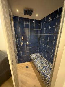 奇维塔韦基亚Hotel Smart Cruise的蓝色瓷砖浴室设有淋浴长凳
