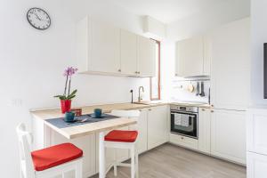 布雷西亚House MaGa - by Host4U的白色的厨房配有白色的橱柜和红色的点缀